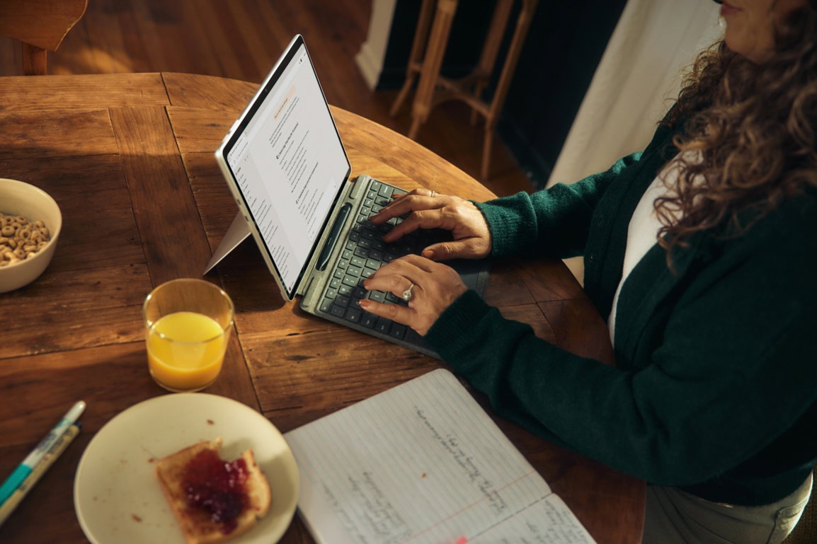 woman-typing-on-laptop-at-wooden-table-with-breakfast-.jpg Woman typing on laptop at wooden table with breakfast.