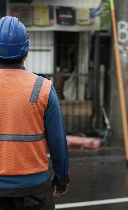 a-man-in-an-orange-vest-and-a-blue-helmet.jpg a man in an orange vest and a blue helmet
