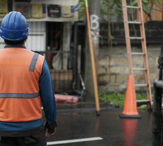 a-man-in-an-orange-vest-and-a-blue-helmet.jpg a man in an orange vest and a blue helmet
